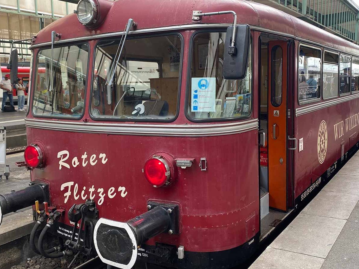 Am Bahnhof steht eine historische Bahn, der rote Flitzer.