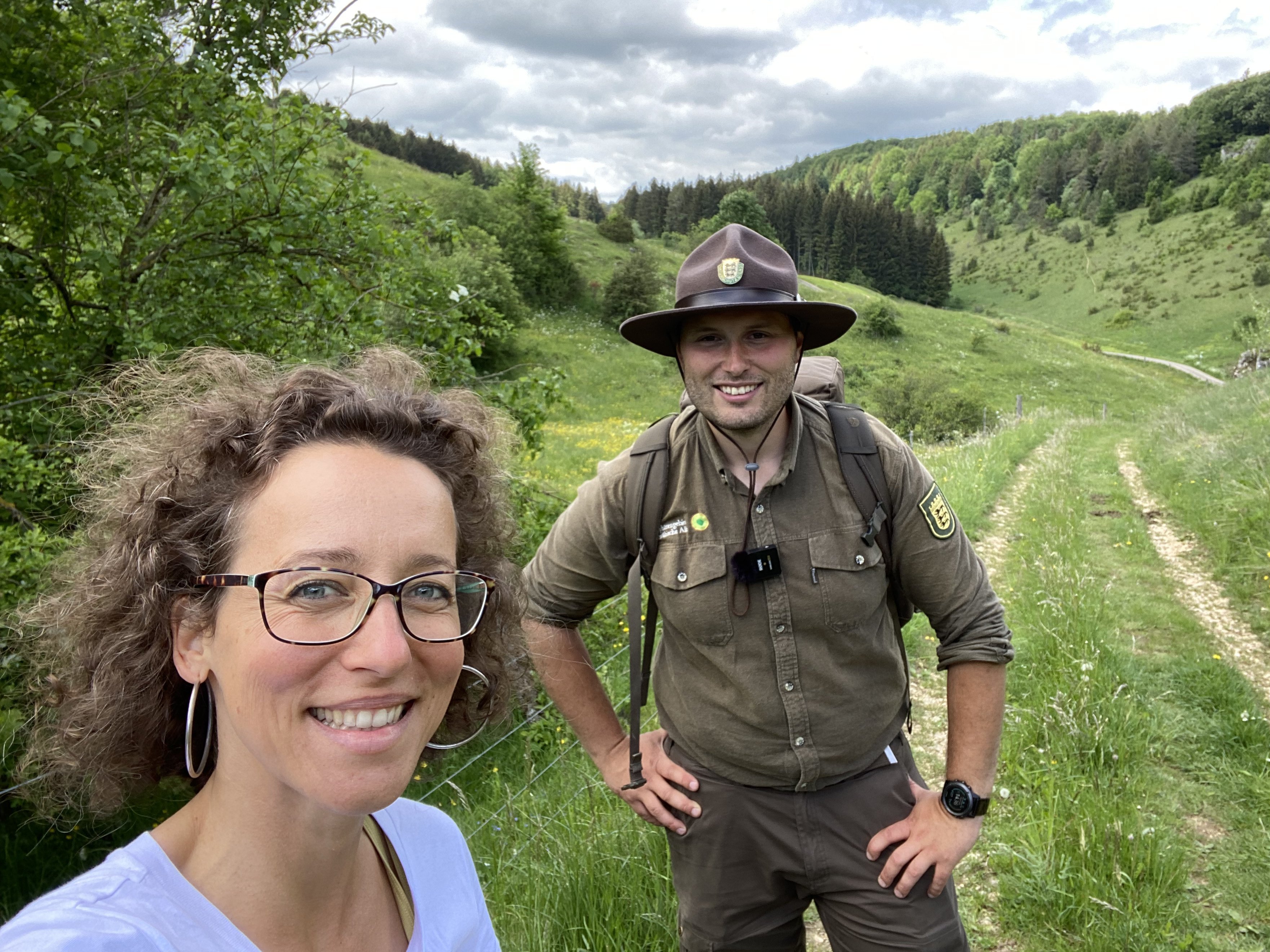 Frau steht mit einem Ranger in der Natur.