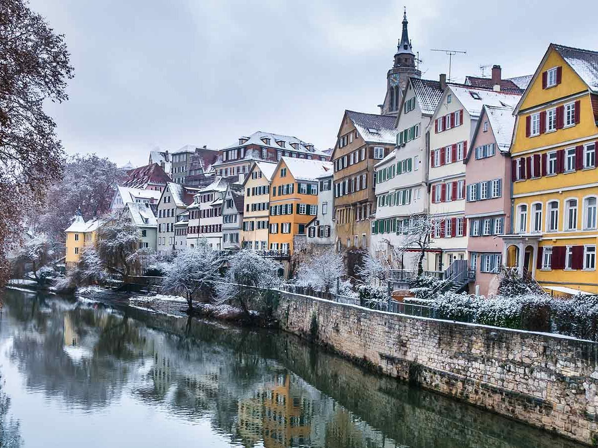 Neckarfront in Tübingen im Winter. Bunte Fachwerkhäuser zieren einen Fluss.