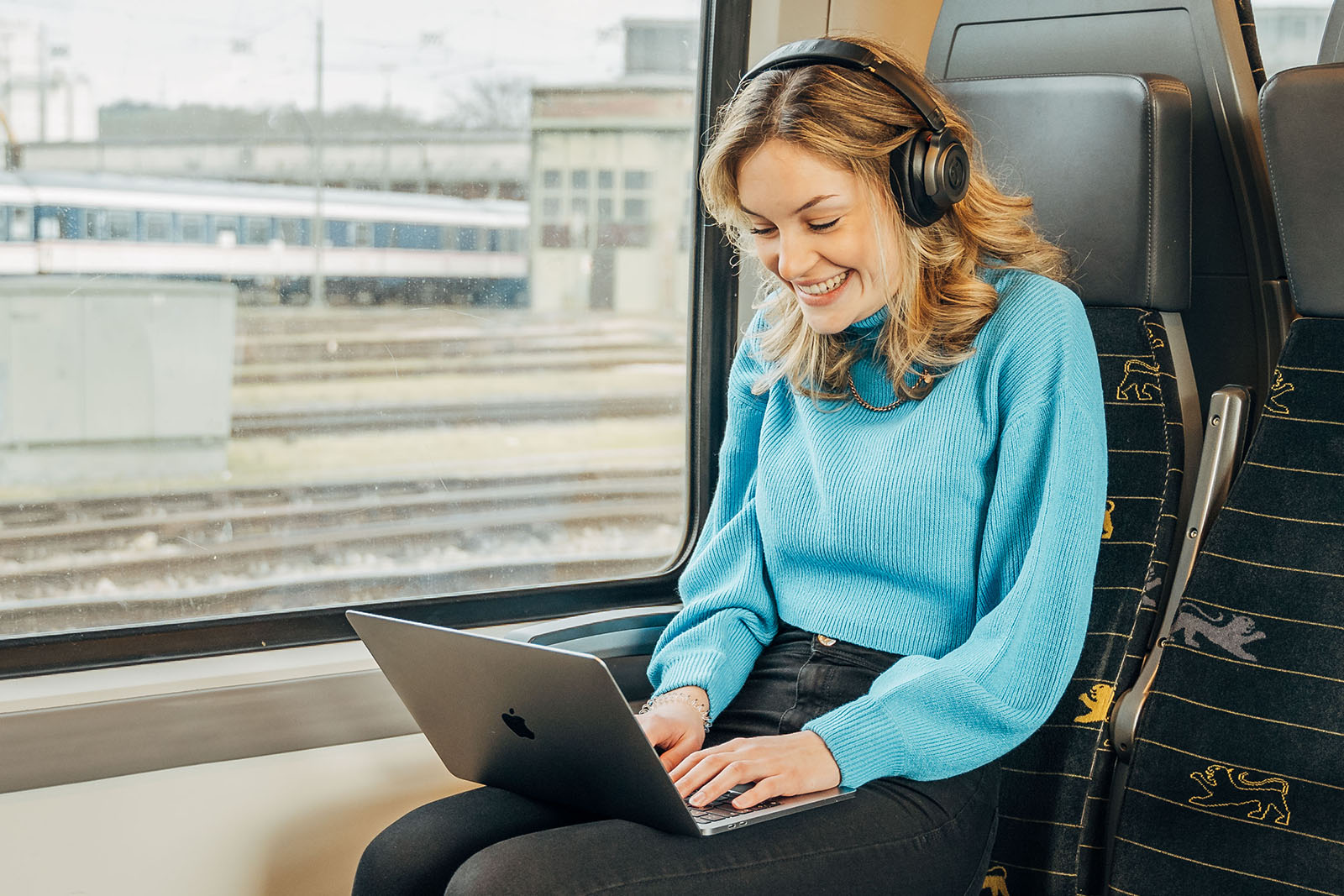 Junge Frau mit Laptop im Zug