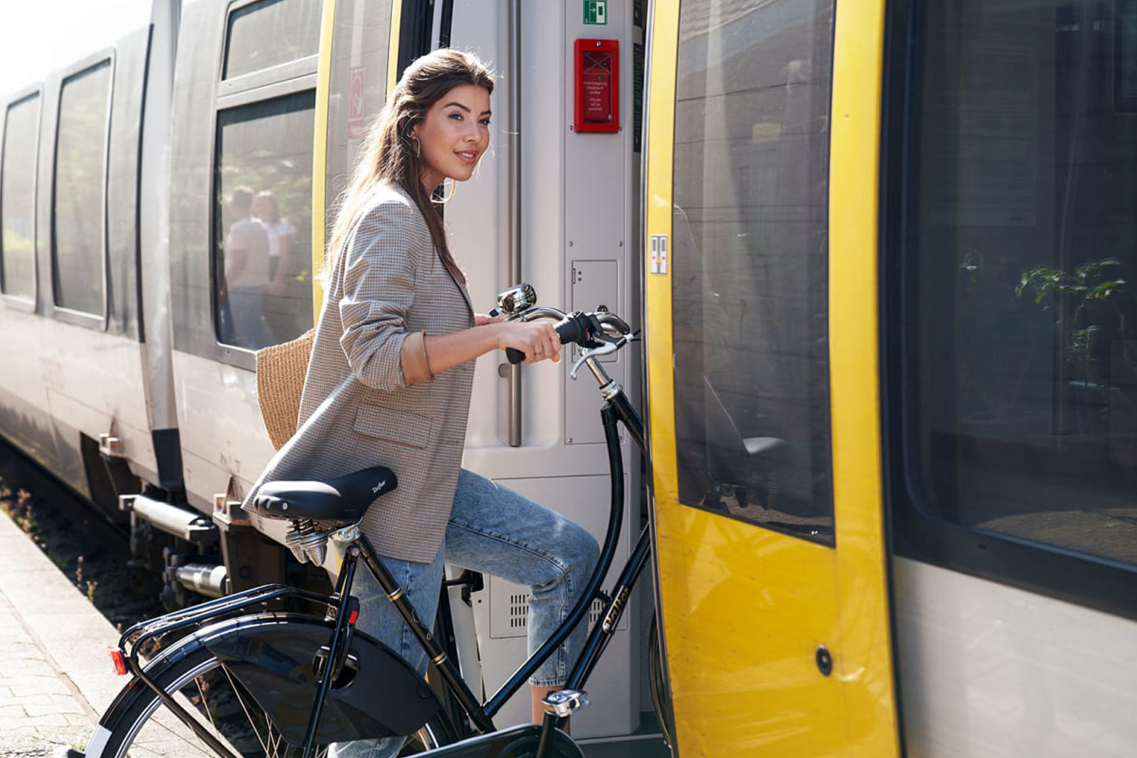 Frau mit dem Fahrrad steigt in einen Zug