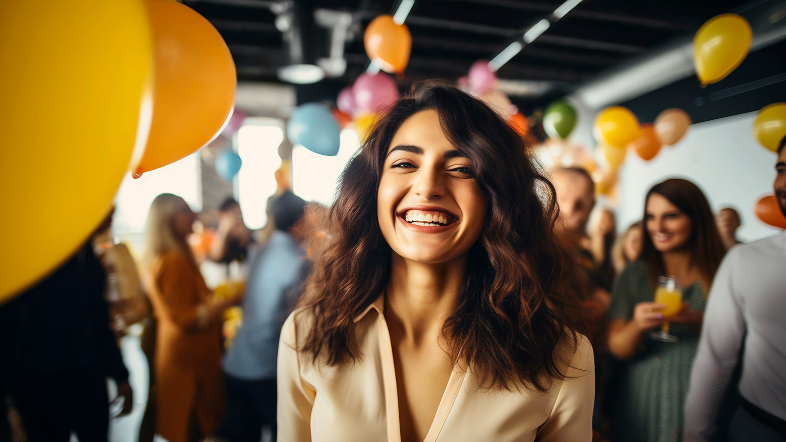 Frau lächert in die Kamera und um sie herum sind Menschen und gelbe Luftballons.