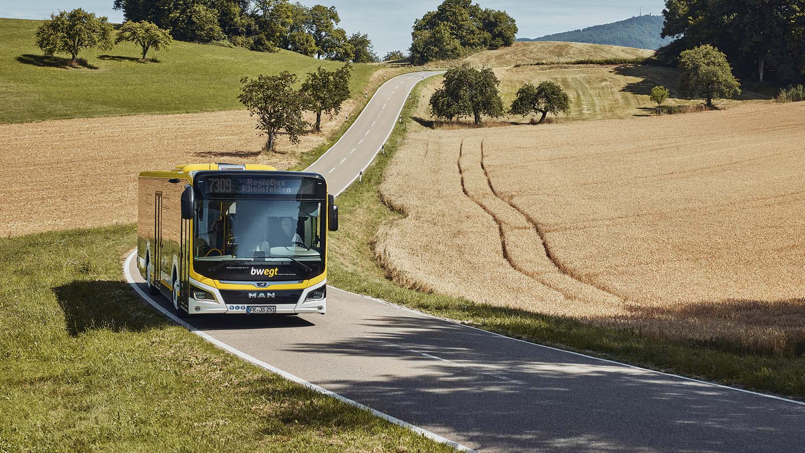 Ein bwregiobus fährt durch ein ländliches Gebiet