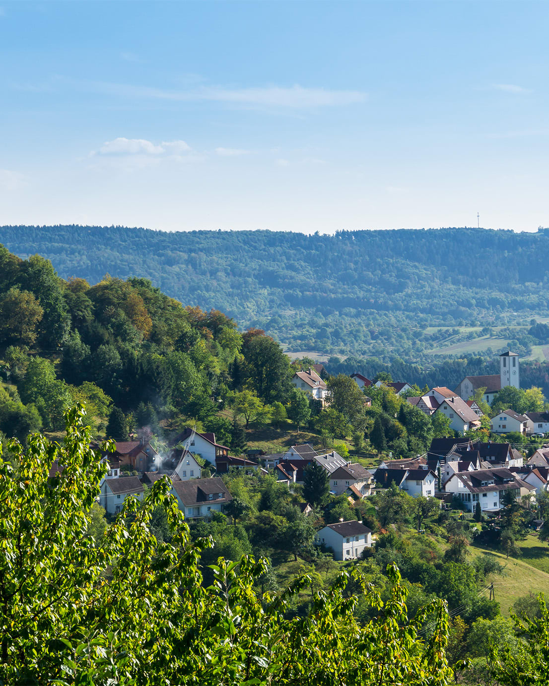 Eine malerisches Dorf in ländliche Umgebung, umgeben von grünen Feldern und sanften Hügeln