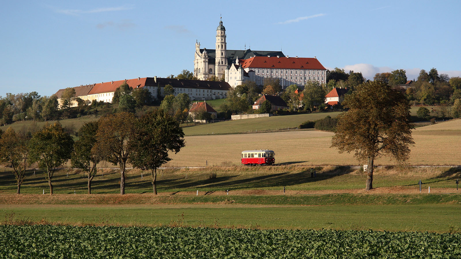 Eine historische Bahn in einer idyllischen Umgebung mit Schloss