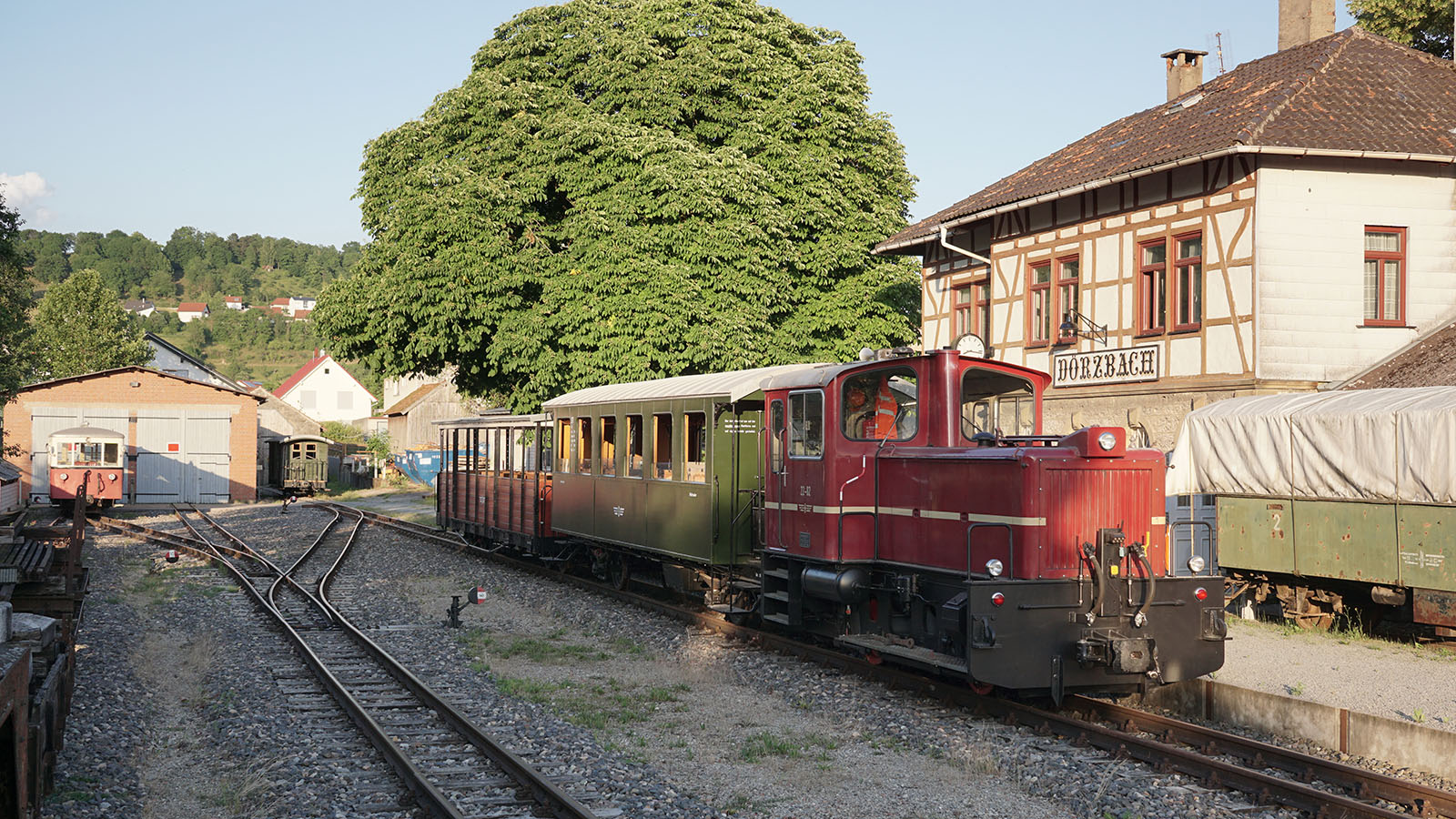 Eine historische Bahn vor einem Fachwerkhaus