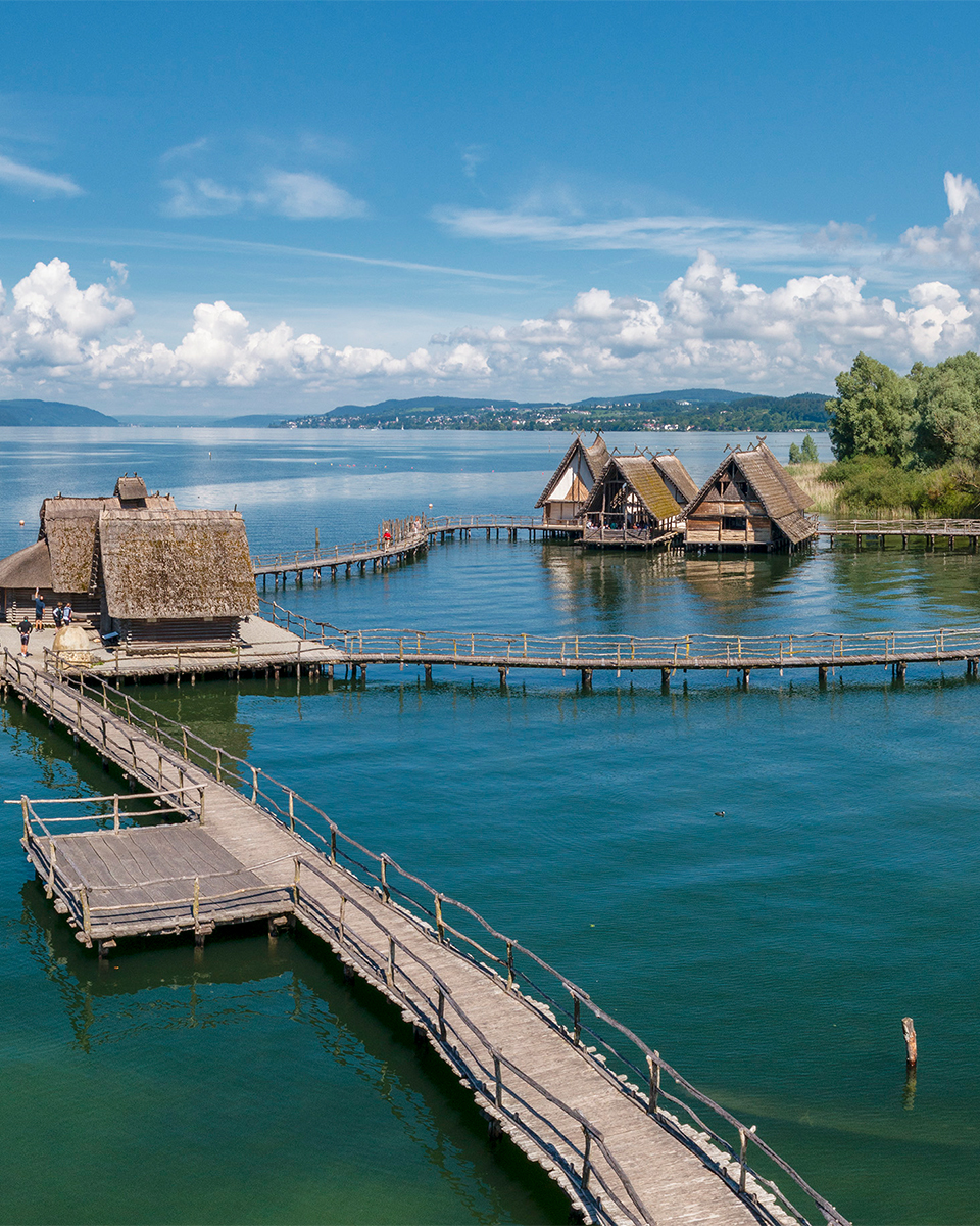 Blick auf die Pfahlbauten, eine kleine Siedlung, die auf Pfählen im Wasser steht, am Bodensee.