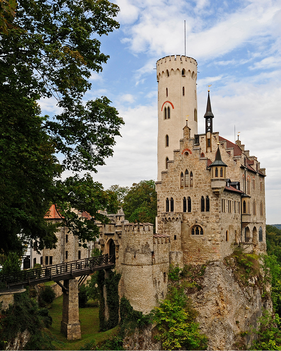 Blick auf Schloss Lichtenstein: Ein Schloss, das auf einem Felsen thront und nur per Brücke zu erreichen ist.