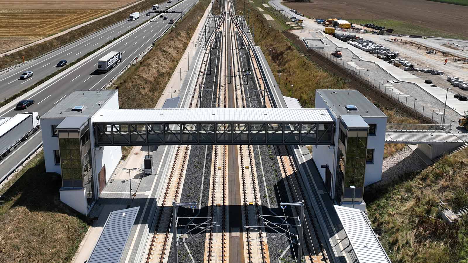 Blick auf eine Personenbrücke am Bahngleis des Merklinger Bahnhofs.