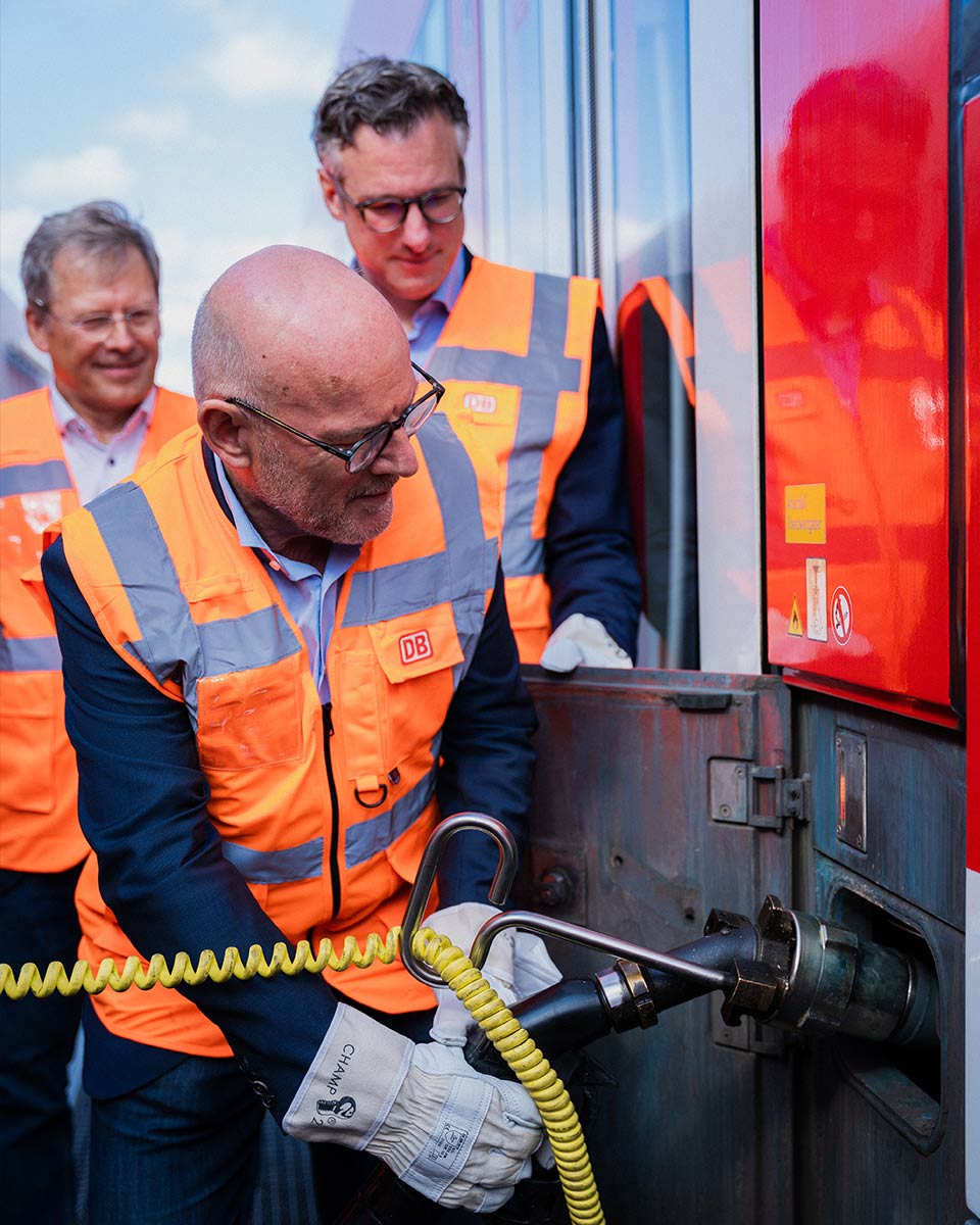 Verkehrsminister Hermann betankt eine Bahn mit Biokraftstoff.