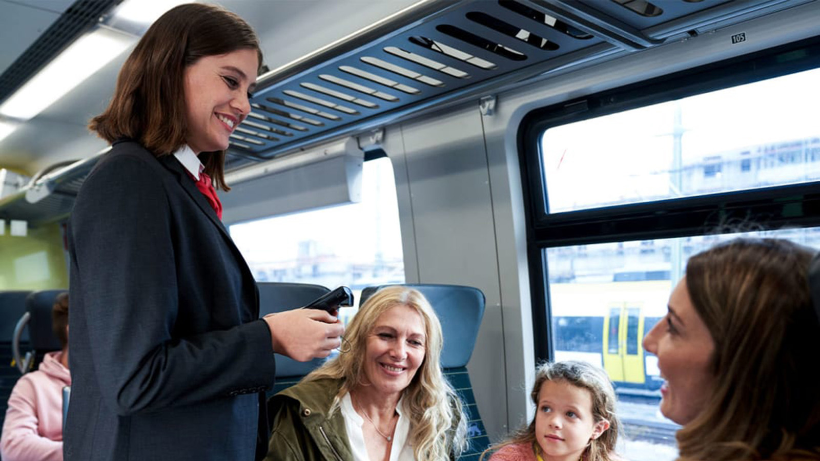 Eine Kundenbetreuerin unterhält sich mit den Fahrgästen